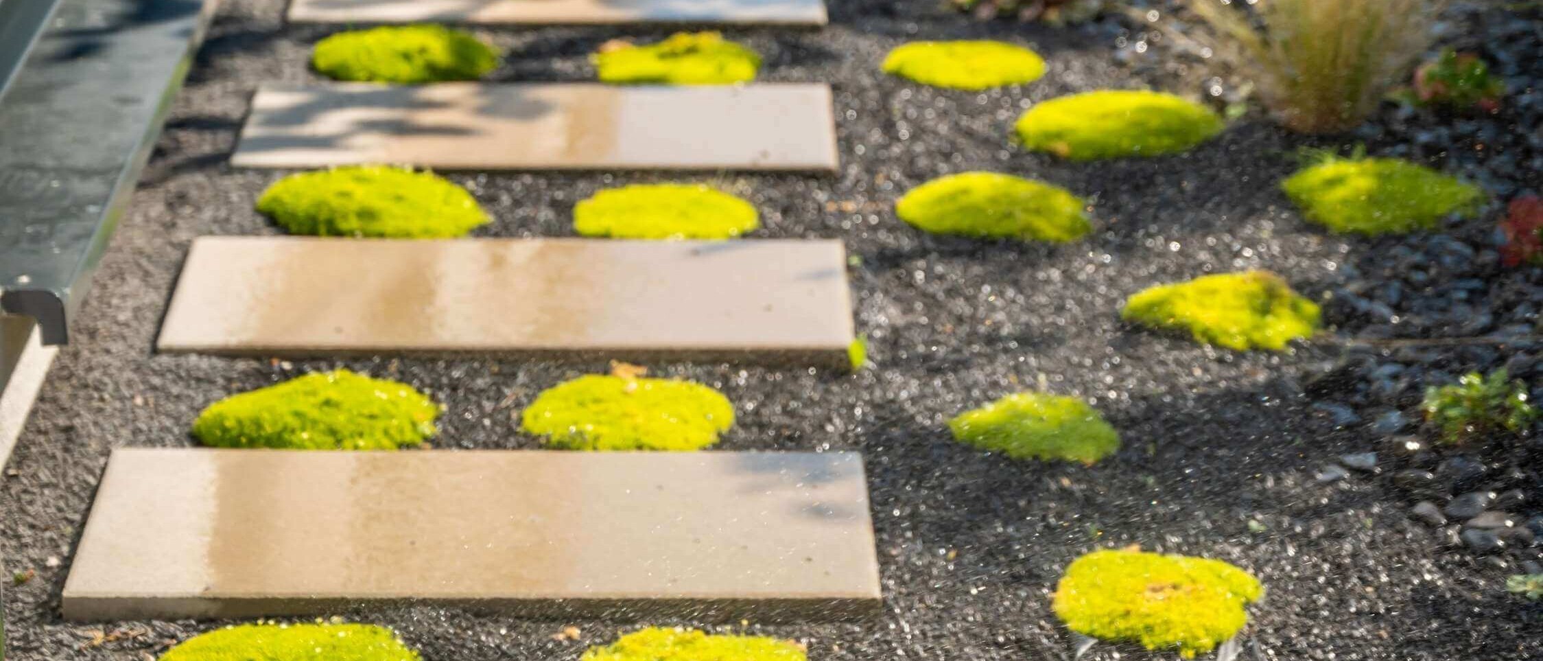Paved areas in the garden – walkway and terrace made of interlocking paving stones with decorative flower beds