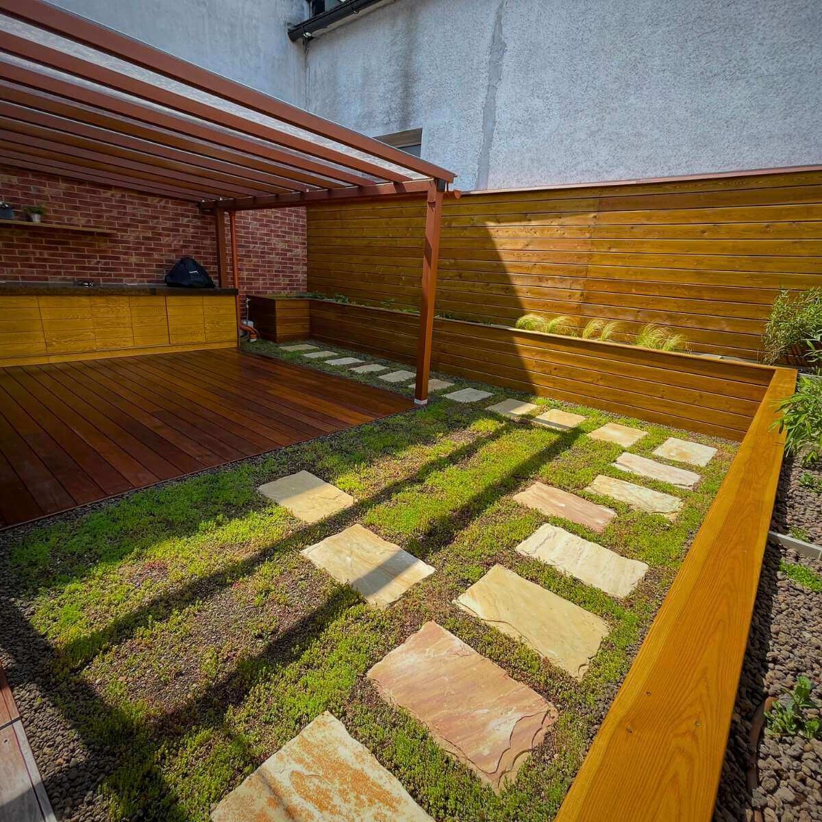 Vonkajšia terasa s okrasnou výsadbou rastlín od Dream Garden – moderný exteriérový priestor pre relaxáciu a stolovanie
